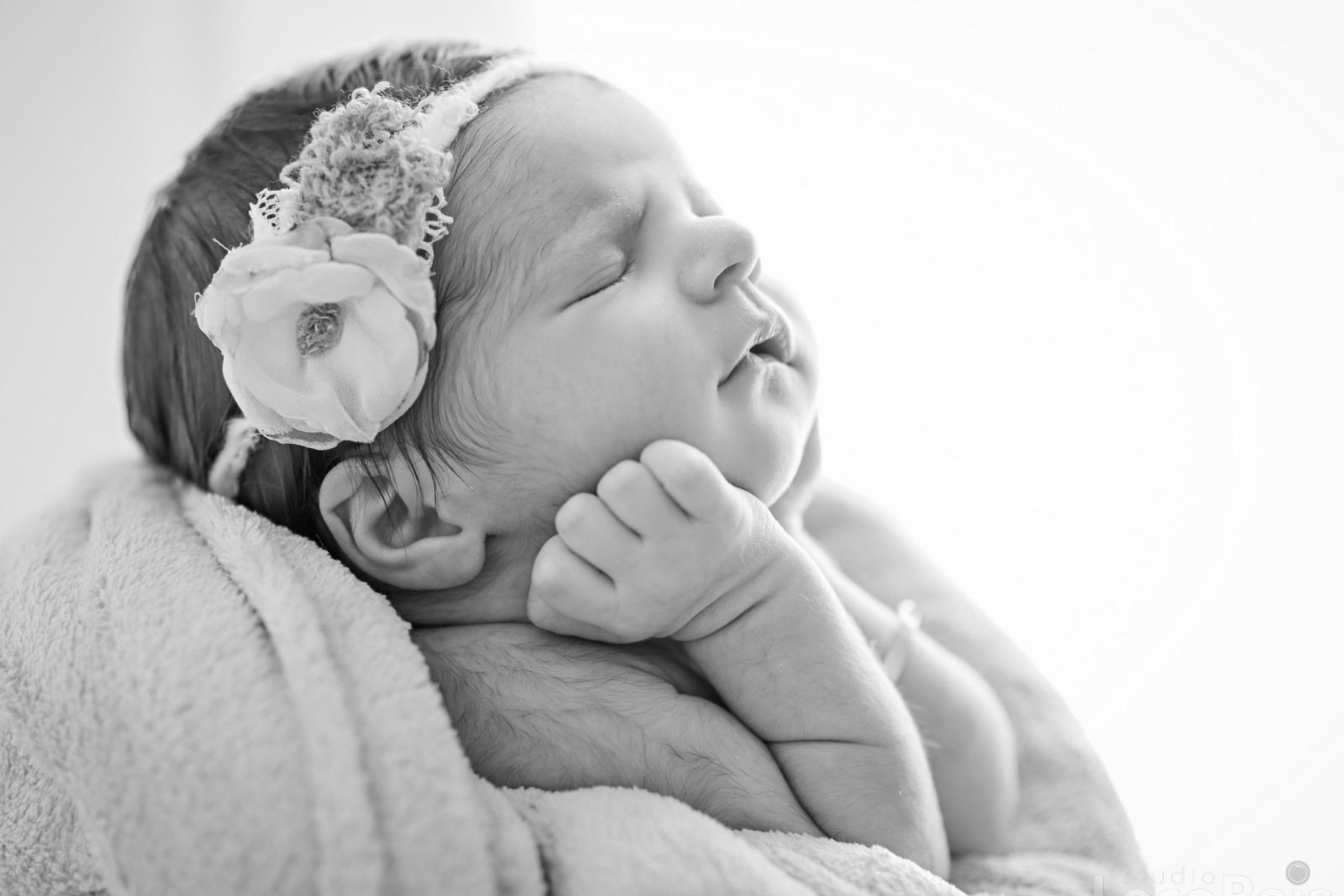 Recém-nascido tranquilo nos braços simbolizando cuidados acolhedores com o bebê em Belo Horizonte